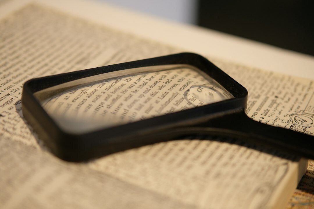 open mystery book with magnifying glass